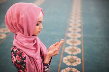 ahşap boncuk tutan çiçek elbise, bir Müslüman, bir camide oturan kız