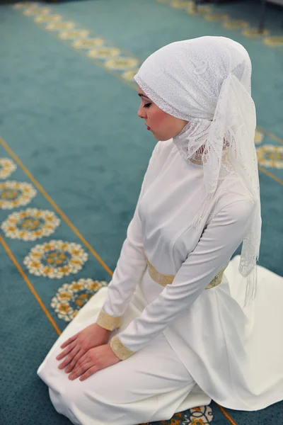 Unga muslimska be i en moské, sitter i riktning mot qibla, händerna på knäna, slutar bön, vittne, Rukn bönen — Stockfoto