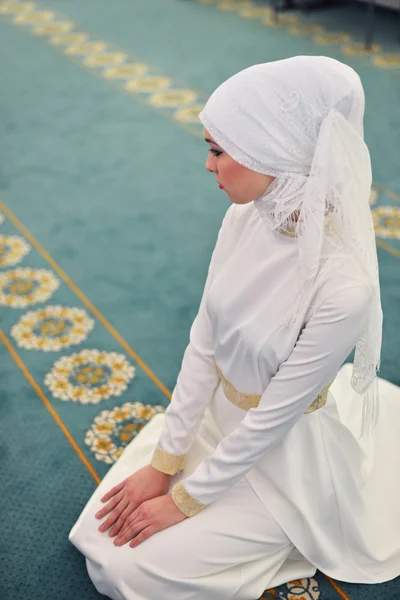 Unga muslimska be i en moské, sitter i riktning mot qibla, händerna på knäna, slutar bön, vittne, Rukn bönen — Stockfoto
