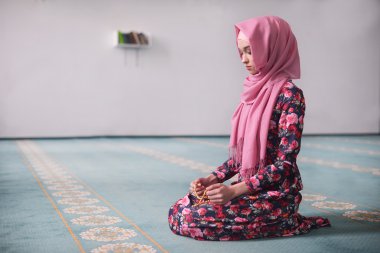 ahşap boncuk çiçek elbiseli genç Müslüman bir camide oturan kız sıralar, daha önce onun ellerinde niyaz kıble yönünü oturan, dua biten, şahit, dua Rukn