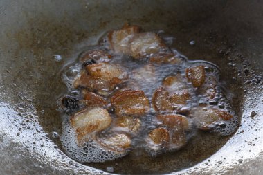 Demir bir tavada kızgın yağda kızartılmış domuz eti. Gıda hazırlığının temel görüntüsü.