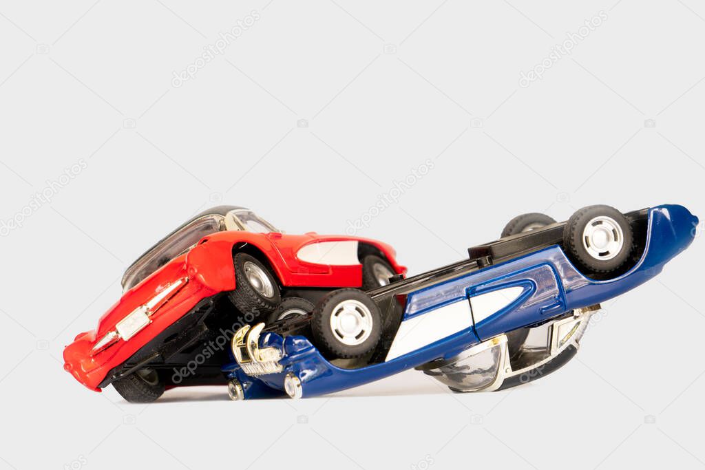Cars crashed and overturned. Red and blue toy cars are made of steel. on isolated white background.