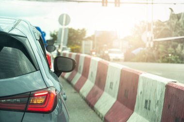 Şehrin asfalt yolunda giden bir arabanın arka tarafında. Kırmızı ışıkta sırada bekliyor. Yolun ortasına bir bariyer mi yerleştirildi?.