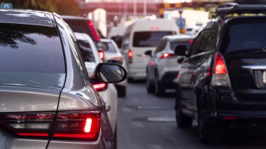 Lüks bronz arabaların arka tarafında. Fren lambasını yakarak. Gündüz vakti birçok arabanın olduğu bir trafik sıkışıklığı. Şehirdeki birçok araba bulanıklaştı..