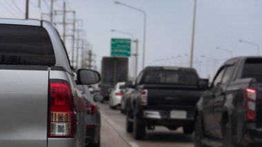 Yoldan geçen bir kamyonetin arka tarafında. Birkaç araba ilerliyordu. Tayland 'da elektrik direklerinin, elektrik hatlarının ve trafik işaretlerinin arkaplanı.