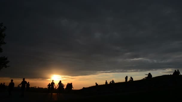 Zonsondergang en silhouet mensen op een berg — Stockvideo