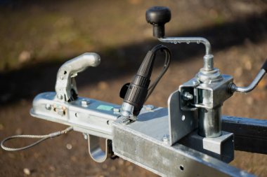 Çağdaş çekme ve taşıma ekipmanlarının güvenilirliğini, faydasını ve işlevselliğini temsil eden el kolu ve elektrik prizi olan metal römork bağlantısı.