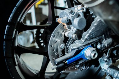 Detaylı motorsiklet arka tekerleği delinmiş fren pervanesi ve kalibre teknoloji, kontrol ve yarış ve yol performanslarında kullanılan yüksek hızlı spor motosikletlerinin fren performansını temsil ediyor.