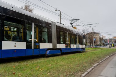 Çevre dostu toplu taşımacılık ve sürdürülebilir şehir tasarımı için kentsel hareketlilik teknolojisini gösteren konut semtindeki yeşil hat bölümünde çağdaş elektrik tramvayı hareket ediyor