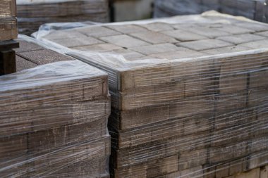 Kumaş lojistik, endüstriyel organizasyon ve yol ve kaldırım işleri için altyapı geliştirme malzemelerini gösteren şehir inşaatı için hazırlanmış paletlere sarılmış beton kaldırım taşları