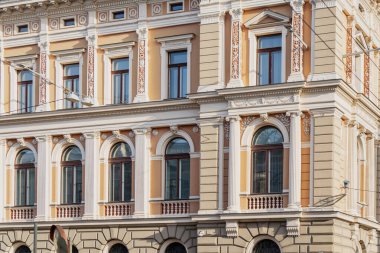 Riga 'daki tarihi neoklasik bina dekoratif pencereler ve dekoratif sütunlar mimari restorasyon detaylarını, kentsel miras tasarımını ve zarif dış işçiliğini gösteriyor.