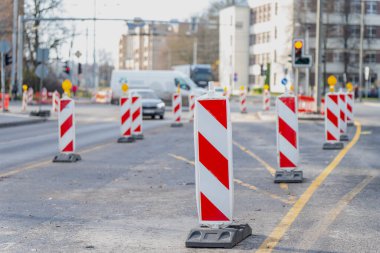 Riga şehir caddesi, altyapı onarımı, şerit yeniden yapılandırması ve belediye karayolu bakım düzenlemesini temsil eden geçici yol işaretleri ve engellerle inşa halinde.