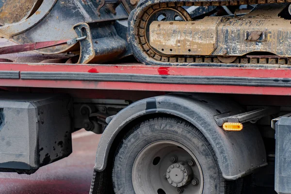 Taşıma, bakım ve endüstriyel nakliye işlemleri için lojistik işlemler sırasında taşımacılık kamyon platformunda kazıcı şasisi ile takip edilen inşaat ekipmanları