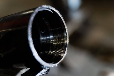 Fabrika detayları, ekipman parçası arayüzü ve işlenmiş metal yüzeyi montaj işlemleri için hazır hale getiren açıkta bırakılmış makine işaretleriyle endüstriyel başlıklı tüp ucu