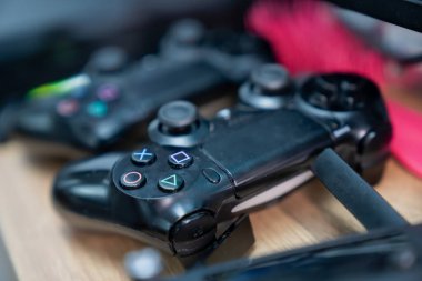 Renkli düğme simgeleri, ergonomik kavrama yüzeyleri ve kısmi aygıt kenarları dinamik teknoloji sahnesi yaratan modern oyun denetleyicileri kümesi