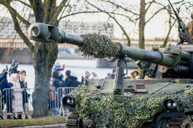 NATO kara kuvvetleri tankı kamuflaj ağı ve müttefik operasyonel ve savunma faaliyetleri sırasında sergilenen görünür taret donanımı ile kaplı ana silah