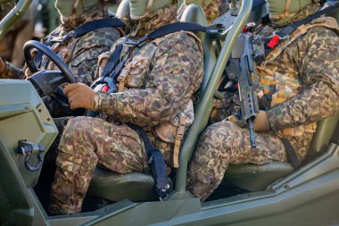 NATO askerleri hafif bir askeri araçla tam kamuflaj teçhizatı içinde hareket kabiliyetlerini, taktik becerilerini ve bölgesel savunma duruşlarını güçlendirdiklerini gösteriyorlar.