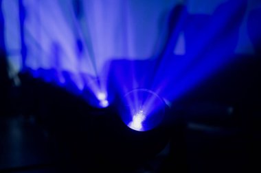 LED 'in hareket eden farları sisli bir ortamda oyulmuş mavi ışınları yansıtıyor, etkinlik yapımında kullanılan modern eğlence aydınlatma sistemlerini gösteriyor