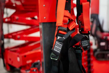 İç inşaat makineleri sergisi sırasında endüstriyel asansör yapısında asılı duran emniyet kemeri ekipmanları boy koruma ekipmanlarını gösteriyor.