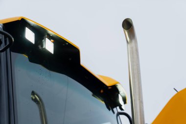 Entegre LED çalışma aydınlatma ve paslanmaz çelik egzoz sistemini gösteren ağır ekipman kabinine ayrıntılı bir göz atın. Güvenilir alan performansı için büyük inşaat makinelerinde kullanılır.