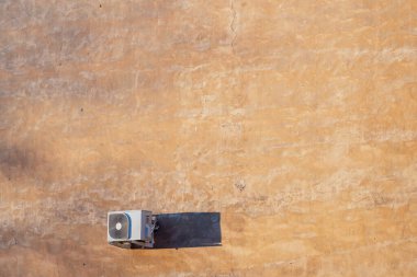 Çatıdaki havalandırma ünitesinin hava görüntüsü dokulu yüzeye gölge düşürüyor, HVAC sistem kurulumunu ve inşa hizmetleri sektörünü vurguluyor