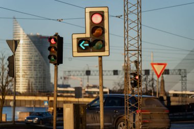 Şehir kavşağında kırmızı ışık ve yön oku olan şehir trafik ışıkları, yol trafik kontrol sistemlerini gösteriyor, altyapı sinyalleri veriyor ve kentsel hareketlilik