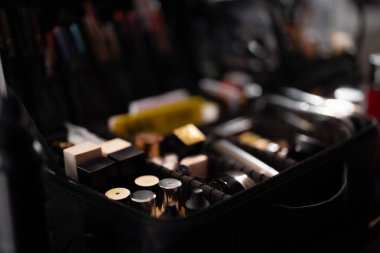 Paletler, dudak ürünleri ve fırça setiyle açık makyaj çantasını gösteren güzellik hazırlama sahnesi, profesyonel makyaj alanındaki araç ve konteynırlara özenli odaklanma