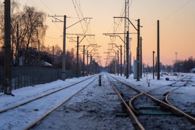 Kar, demiryolu kavşağını birden fazla güzergahla kapladı. Elektrik hatları ve tekrarlanan direklerle akşam ışığında güçlü çizgiler oluşturdu.