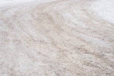 Buzlu yol yüzeyini kum ve toprakla kapatın, kaygan koşulları gösteren kış sokağı dokusu ve güvenlik ve hava kavramları için yer kopyalayın