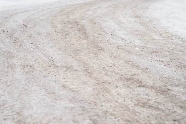 Buzlu yol yüzeyini kum ve toprakla kapatın, kaygan koşulları gösteren kış sokağı dokusu ve güvenlik ve hava kavramları için yer kopyalayın