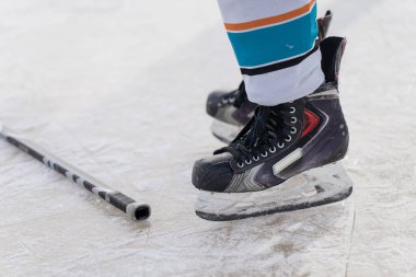 Hokey oyuncusunun ayakları buz kalıbının yanında duran buz kalıbı, ekipman ve atlet hazırlık konsepti pratik, hız ve güç için