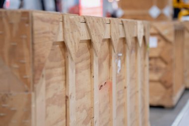 Bulanık arka plan kutularıyla dolu depolama alanında kereste sandığı, uluslararası taşımacılık, lojistik işlemleri ve işlemler için güvenli nakliye konteynırı