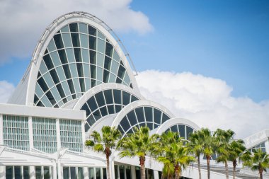 Tropikal palmiye ağaçları ve geometrik çelik ve cam atriyum içeren OCCC dış yüzeyinin modern mimari ayrıntıları