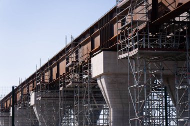 İnşaat mühendisliği iş akışı ve kentsel genişlemeyi temsil eden inşaat platformları ve beton destekli büyük bir üstgeçit inşa ediliyor.