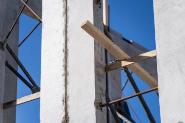 Geçici ahşap desteklere ve dikey açıklığa sahip beton duvar, prefabrik inşaat, site iş akışı ve proje geliştirmesini temsil ediyor