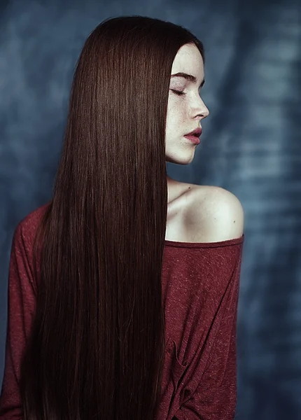 Girl's close portrait in profile with long hair in red sweater — Stock Photo, Image