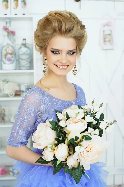 Красивая девушка в синем платье с букетом цветов — стоковое фото