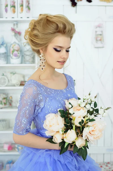 Красивая девушка в синем платье с букетом цветов — стоковое фото