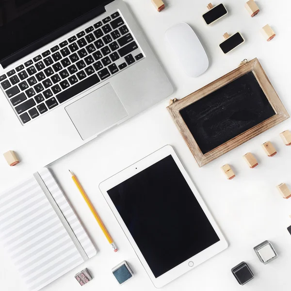 Ordenador portátil, tableta, ratón, cuaderno de bocetos, pizarra y sello aislados sobre fondo blanco. Puesta plana —  Fotos de Stock