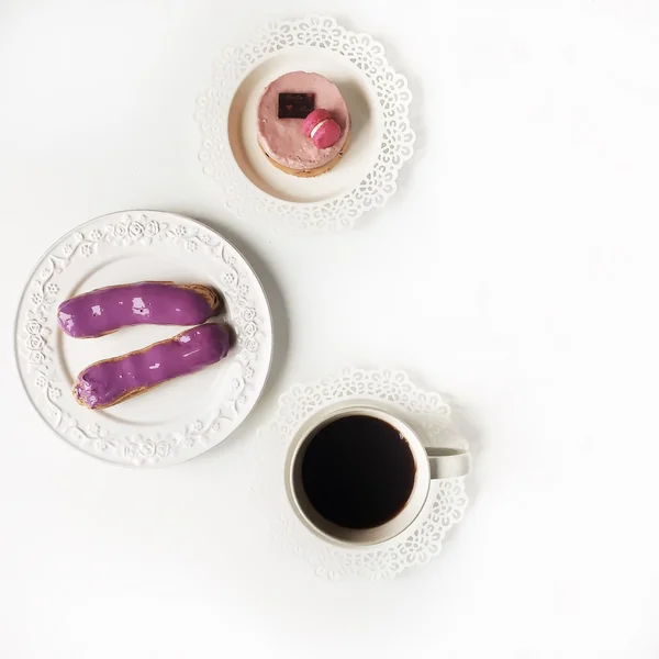 Kawa i fioletowe ciasta na białym tle — Zdjęcie stockowe