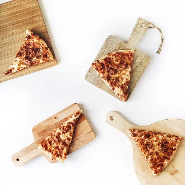 Bitar av pizza på skärbrädor — Stockfoto