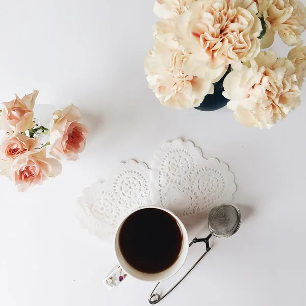 Vista aérea de la taza de café negro, rosas y clavel aislados sobre fondo blanco — Foto de Stock