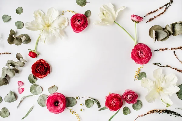 Marco de corona con rosas rosadas y rojas o ranúnculos, tulipanes blancos y hojas verdes — Foto de Stock