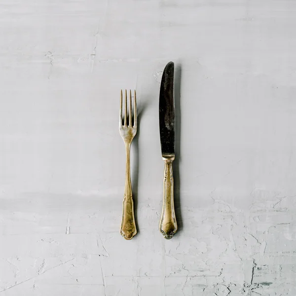 Goldene Gabel und Messer auf grau — Stockfoto