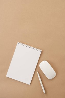 Boş sayfa sarmal defter, fare, pastel bej masadaki kalem. Düz yerde, üst tarafta. Boşluk düzenleme şablonu arka planını kopyala.