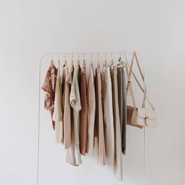 Beyaz arka planda asılı kadın modası parlak pastel giysiler. Minimalist moda blogu kavramı.