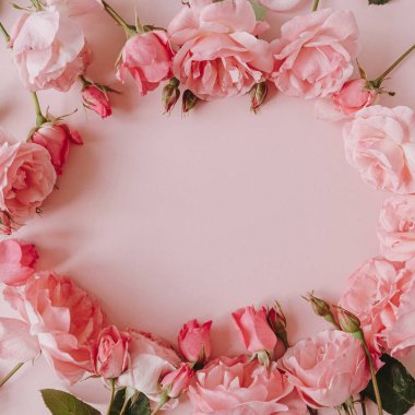 Sevgililer Günü / Anneler Günü tebrik kartı modeli. Boş kopya alanı olan çerçeve çelengi. Pembe arka planda güzel pembe güller. Düz konum, üst görünüm minimalist çiçek kompozisyonu.