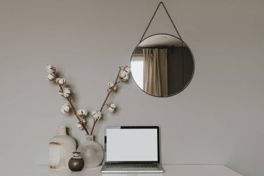 Boş ekran laptop. Ofis masası çalışma alanı, pamuk fabrikası, vazo, gri arka planda ayna. Web sayfası şablonunu kopyala. Blogger, taşeroncu serbest kahraman başlığı.