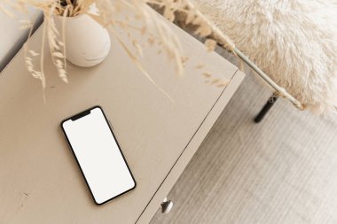 Bej renkli pastel masanın üzerinde boş ekran cep telefonu düzlüğü. Düz yerde, üst tarafta. Boşluk düzenleme şablonunu kopyala.