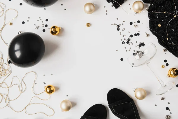 空のコピースペースモックアップフレームとクリスマス 新年のお祝いのコンセプト シャンパングラス 輝くコンフェッティ ドレス ベーブル 白い背景の靴 最小限の休日パーティー構成 — ストック写真